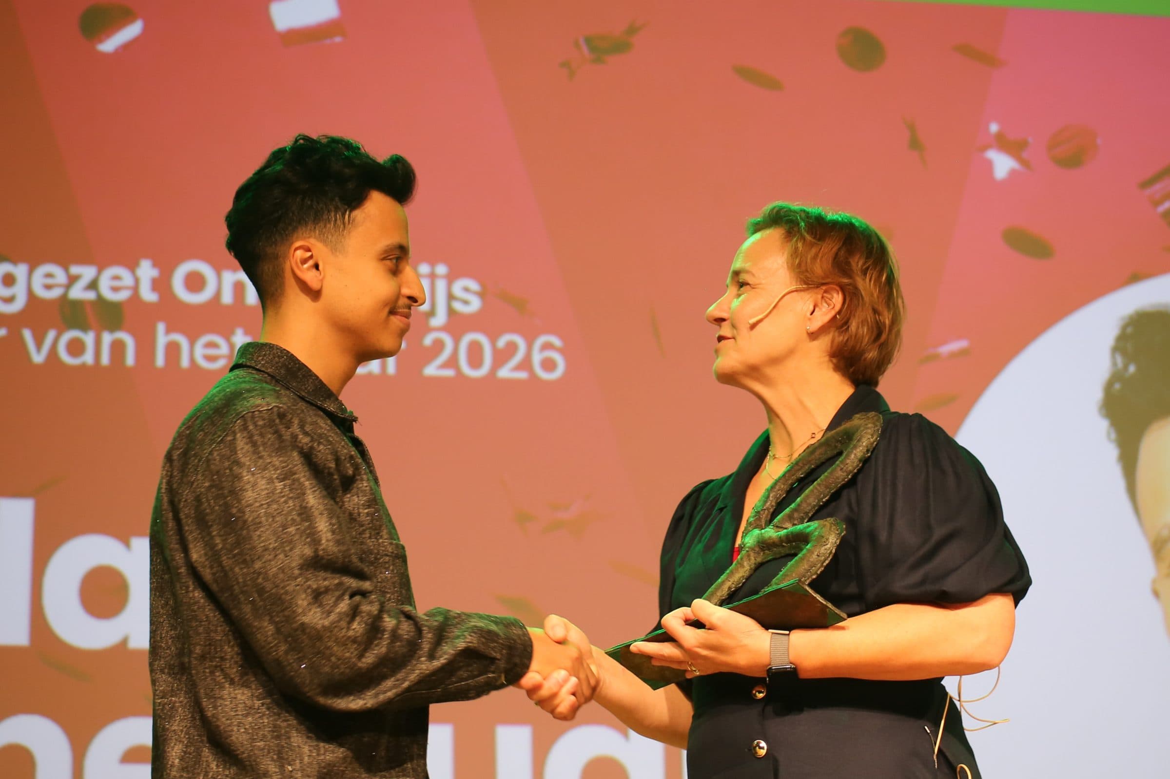 Bilal krijgt op het podium de trofee van Leraar van het Jaar 2026 overhandigd